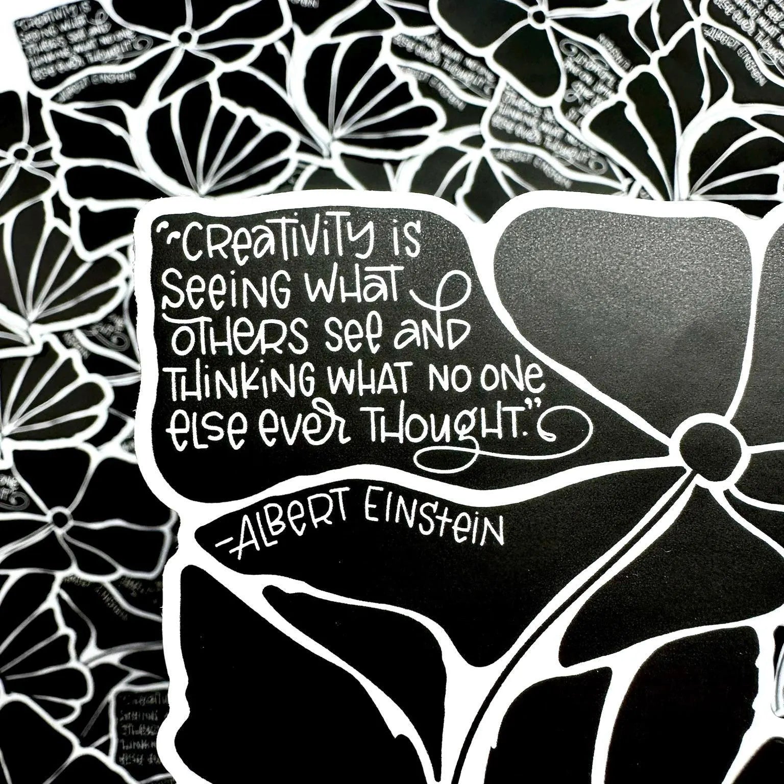 Black and white floral pattern with a quote by Albert Einstein on a black background