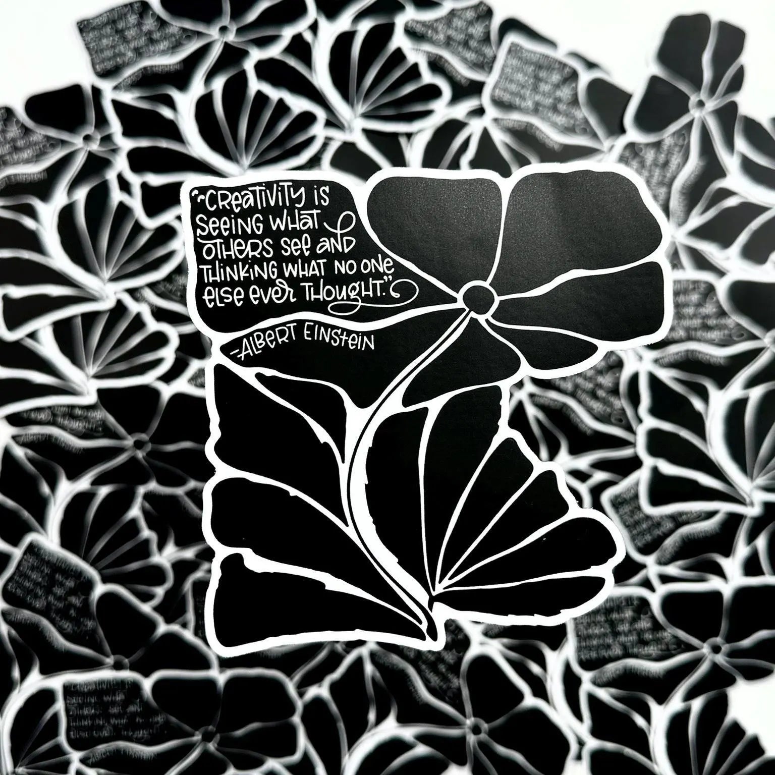 Black and white floral design with a quote by Albert Einstein on a textured background