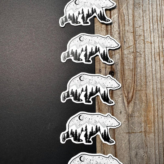 Set of bear-themed stickers with forest design on a wooden surface