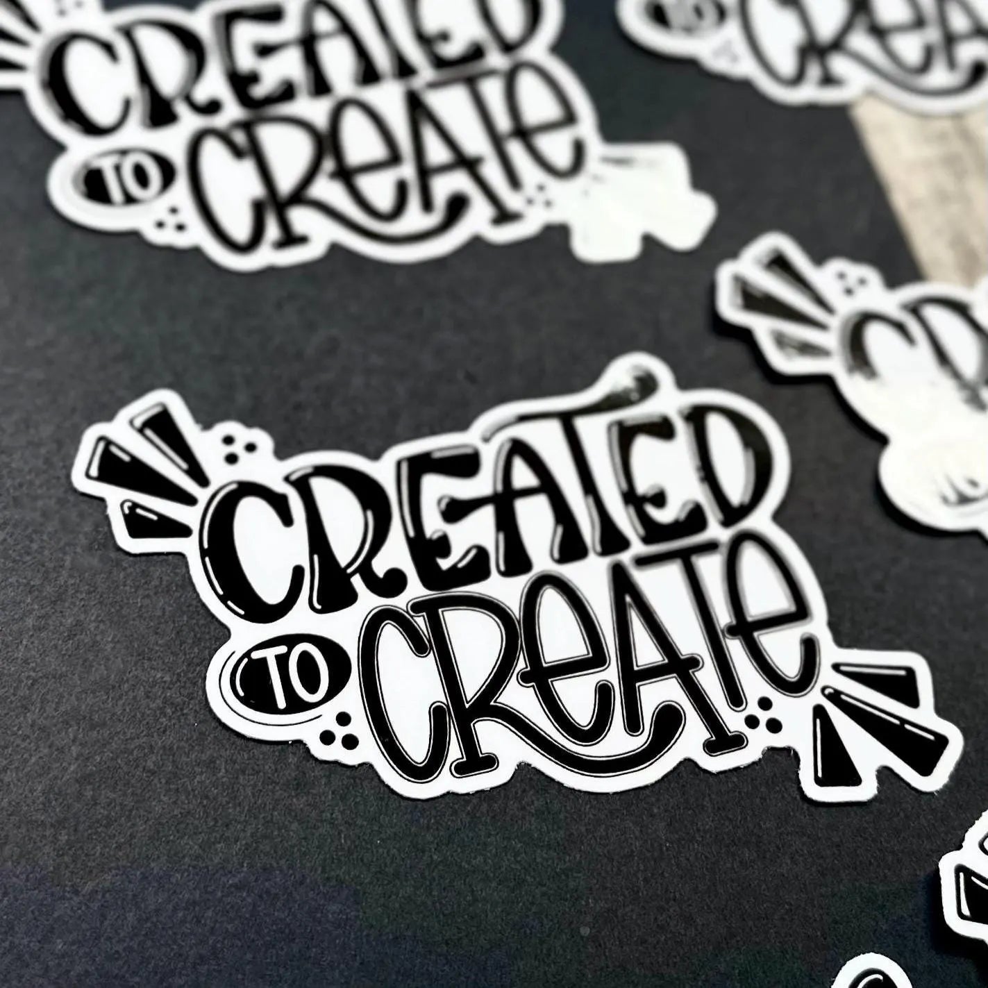 Sticker with 'Created to Create' text on a black background