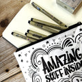 Zippered pen pouch filled with drawing pens and supplies included in the lettering bundle