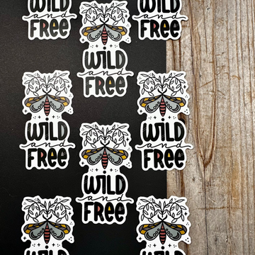 Repeating pattern of 'Wild and Free' stickers with moth designs on a black and wooden background.