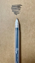 Hand writing Sakura Gelly Roll pen adding raised black ink to a journal page