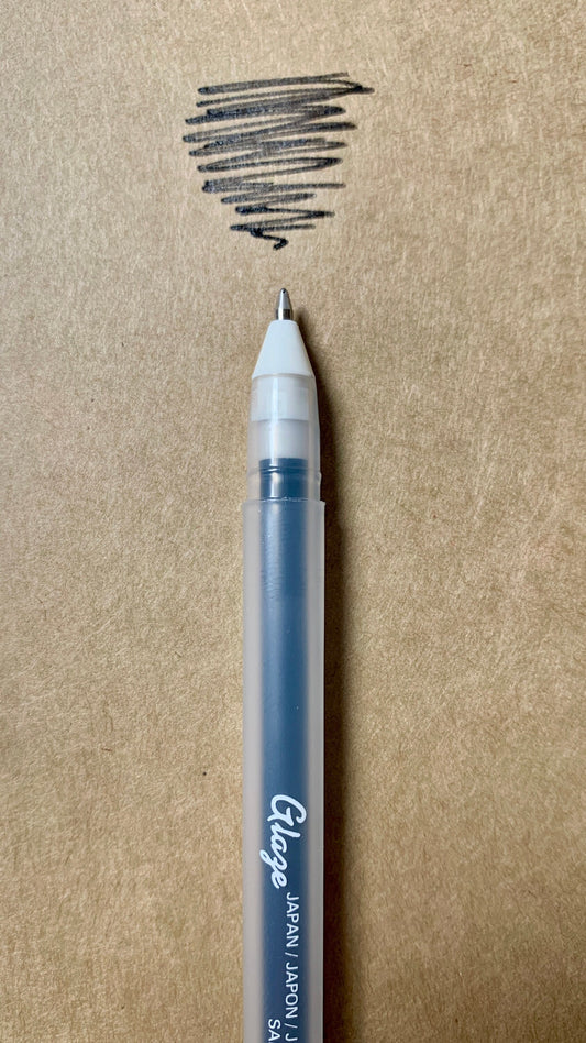 Hand writing Sakura Gelly Roll pen adding raised black ink to a journal page